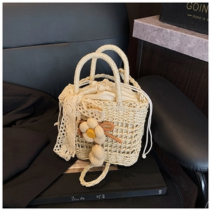 Close-up of hand-woven straw bag with lace trim and interior drawstring liner