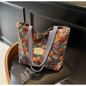 Gros plan sur le tissu floral vintage et les anses tissées d'un grand sac cabas
