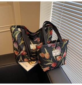 Detail of floral tulip jacquard fabric texture on black tote bag with white woven label