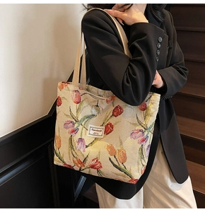 Detail of floral tapestry tote bag featuring colorful tulips and a cotton shoulder strap