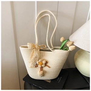 Detailed texture of beige woven handbag with floral lace charms on vintage books