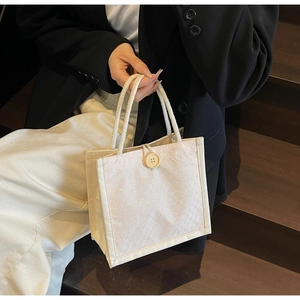 Dettaglio della borsa tote bianco crema con trama trapuntata e manici in corda