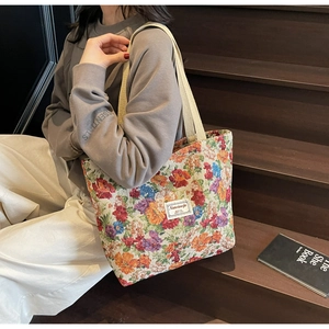 Détail du cabas en jacquard floral avec texture tissée et bandoulière de couleur crème