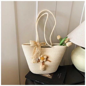Close-up of hand-woven off-white tote bag with floral accents and lace bow detail
