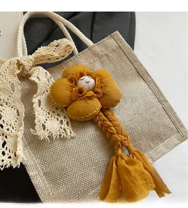 Dettaglio del ciondolo floreale giallo zenzero con ricamo e nappa sulla borsa a mano