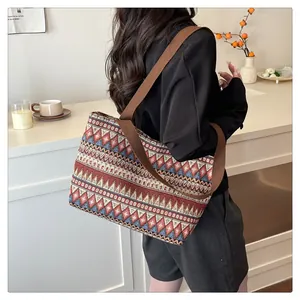 Detail of ethnic geometric patterned canvas tote bag with wide brown shoulder strap