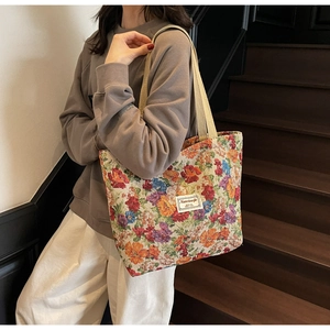 Gros plan détaillé d'un grand sac cabas en toile fleurie porté dans un cadre décontracté