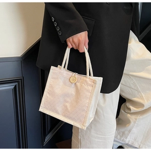 Dettaglio borsa tote in tela beige con manici in corda e trama a conchiglia