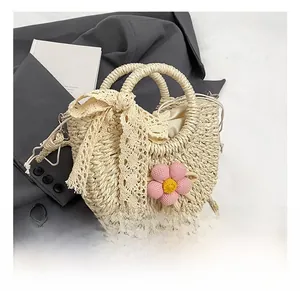 Détails du sac seau en paille avec nœud en dentelle et fleur au crochet