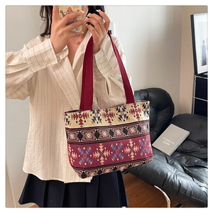 Detailed shot of ethnic woven tote bag with colorful geometric patterns and red strap