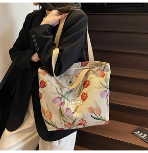 Close-up of canvas tote bag featuring colorful tulip embroidery and woven handles