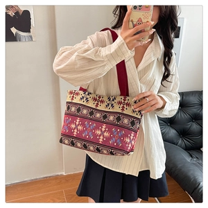 Ethnic embroidered tote bag with geometric tribal patterns shown on a female model