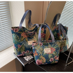 Detailed macro view of large navy jacquard floral tote bags with woven handles