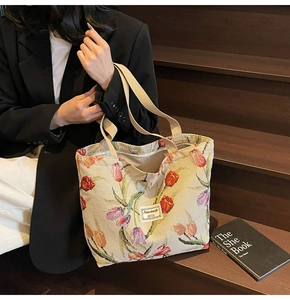 Close-up of woven tote bag featuring vibrant tulip prints and durable shoulder strap