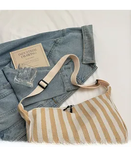 Détail du sac en toile rayé avec sangle tissée et double fermeture éclair noire