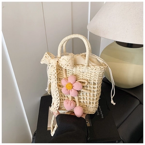 Detail of hand-woven beige tote bag featuring floral accents and lace ribbon bow