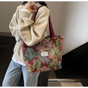 Detail of vintage floral jacquard tote bag featuring large capacity and red woven straps