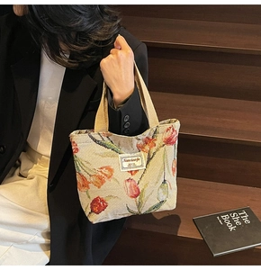 Close-up of beige jacquard tote bag featuring tulip floral pattern and woven texture