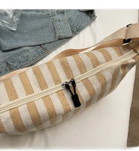 Détail du sac de poitrine en toile rayé jaune et blanc avec double fermeture éclair