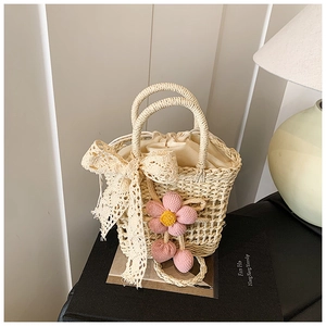 Handwoven straw bag with lace bow decoration and pink crochet flower detail