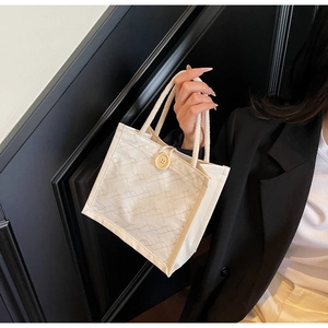 Dettaglio della borsa beige trapuntata con bottone in legno e manico in corda
