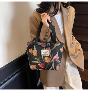 Detail of large tote bag featuring vibrant tulip jacquard pattern on black fabric