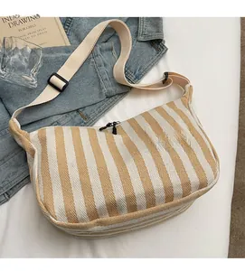 Vue de dessus d'un sac bandoulière en toile rayée avec sangle réglable au style décontracté