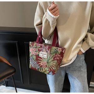 Detail of vintage red and green jacquard embroidery tote bag with woven straps