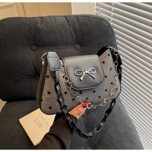 Close-up of gray polka dot bag with wool fabric and decorative silver bow buckle