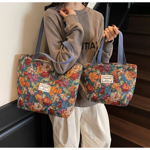 Vue détaillée du sac cabas en brocart floral montrant la texture et les anses tissées