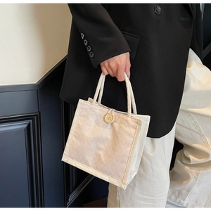 Dettaglio della borsa in lino con bottone in legno e manico in corda intrecciata
