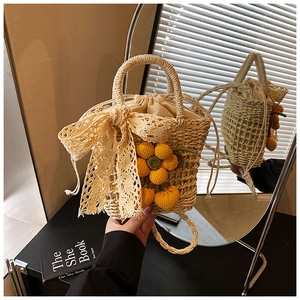 Detail of hand-woven straw bag with crochet yellow flowers and lace ribbon bow decoration