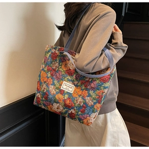 Détail du sac cabas en jacquard floral avec bandoulière violette et étiquette chic