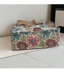 Detail of vintage floral jacquard fabric and reinforced canvas handles on tote bag