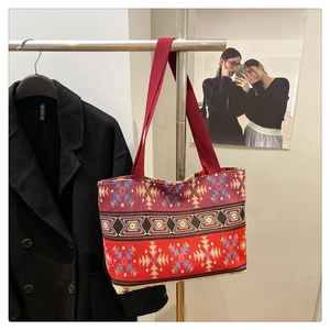 Detail view of ethnic tote bag with red, purple, and black geometric woven patterns
