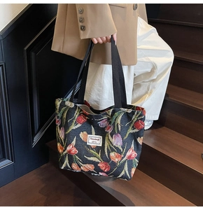 Close-up of vintage black jacquard tote bag featuring vibrant tulip floral patterns