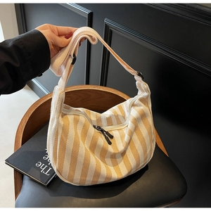 Détail de la bandoulière ajustable et des zips doubles sur le sac hobo rayé