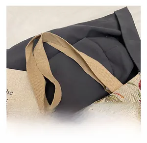 Dettaglio del comodo manico in cotone su una borsa tote in jacquard floreale con ricami