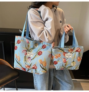 Detail of large and small blue jacquard tote bags with colorful tulip floral patterns