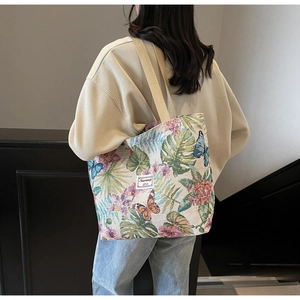 Close-up of canvas tote bag featuring floral butterfly prints and woven texture details