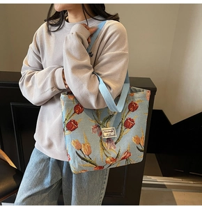 Detail of light blue knitted tote bag with red and yellow tulip jacquard patterns