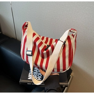 Détail d'un sac cabas en toile à rayures rouges et blanches posé sur un canapé