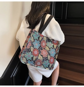 Detailed close-up of large ethnic floral tote bag showing woven texture and canvas straps