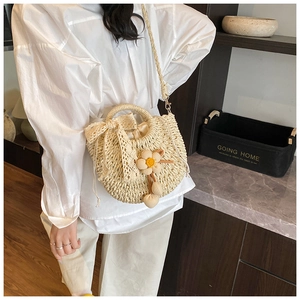 Détail du sac en paille fait main avec nœud en dentelle et fleur au crochet jaune décorative