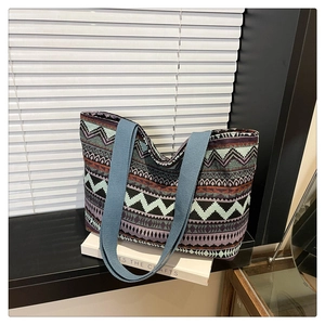 Detail of colorful geometric woven tote bag with a wide teal blue shoulder strap