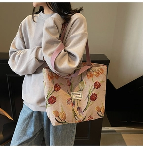 Detail of pink vintage tulip jacquard tote bag with woven shoulder strap and logo patch