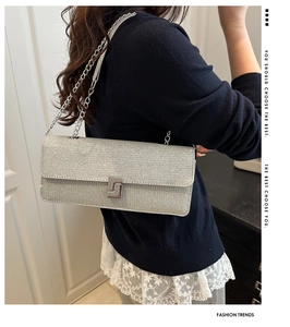 Detail view of sparkly silver rhinestone shoulder bag with metal chain strap and sleek lock