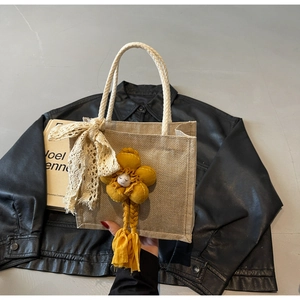 Borsa in lino con manici in corda crema, fiocco in pizzo e ciondolo a fiore giallo