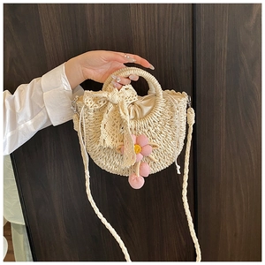 Détail du sac seau en paille avec nœud en dentelle, fleurs et doublure à cordon