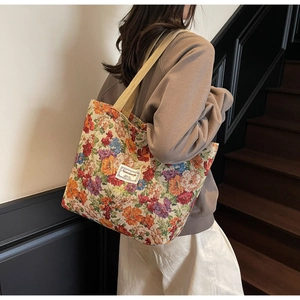 Détail d'un grand sac cabas en toile à fleurs avec larges bandoulières beige